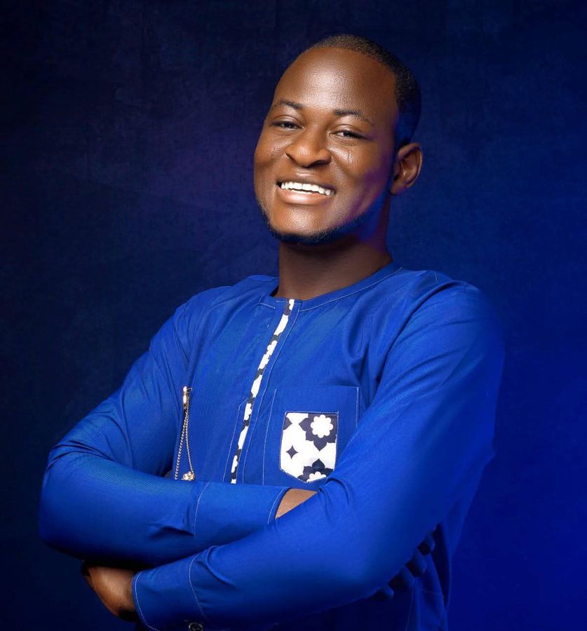 Saliou, fondateur d'Olodo, souriant et les bras croisés, en tenue bleue
